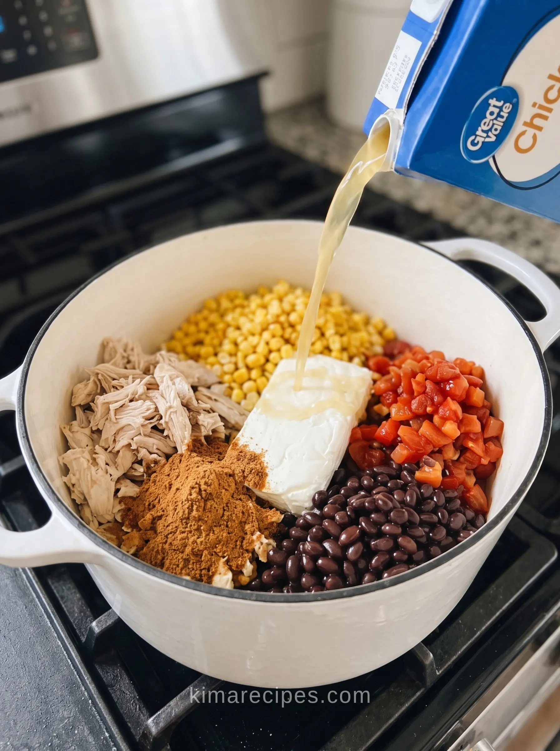 Pouring chicken broth into a Dutch oven of chicken, corn, beans, Ro-Tel, and taco seasoning for cheesy chicken enchilada soup