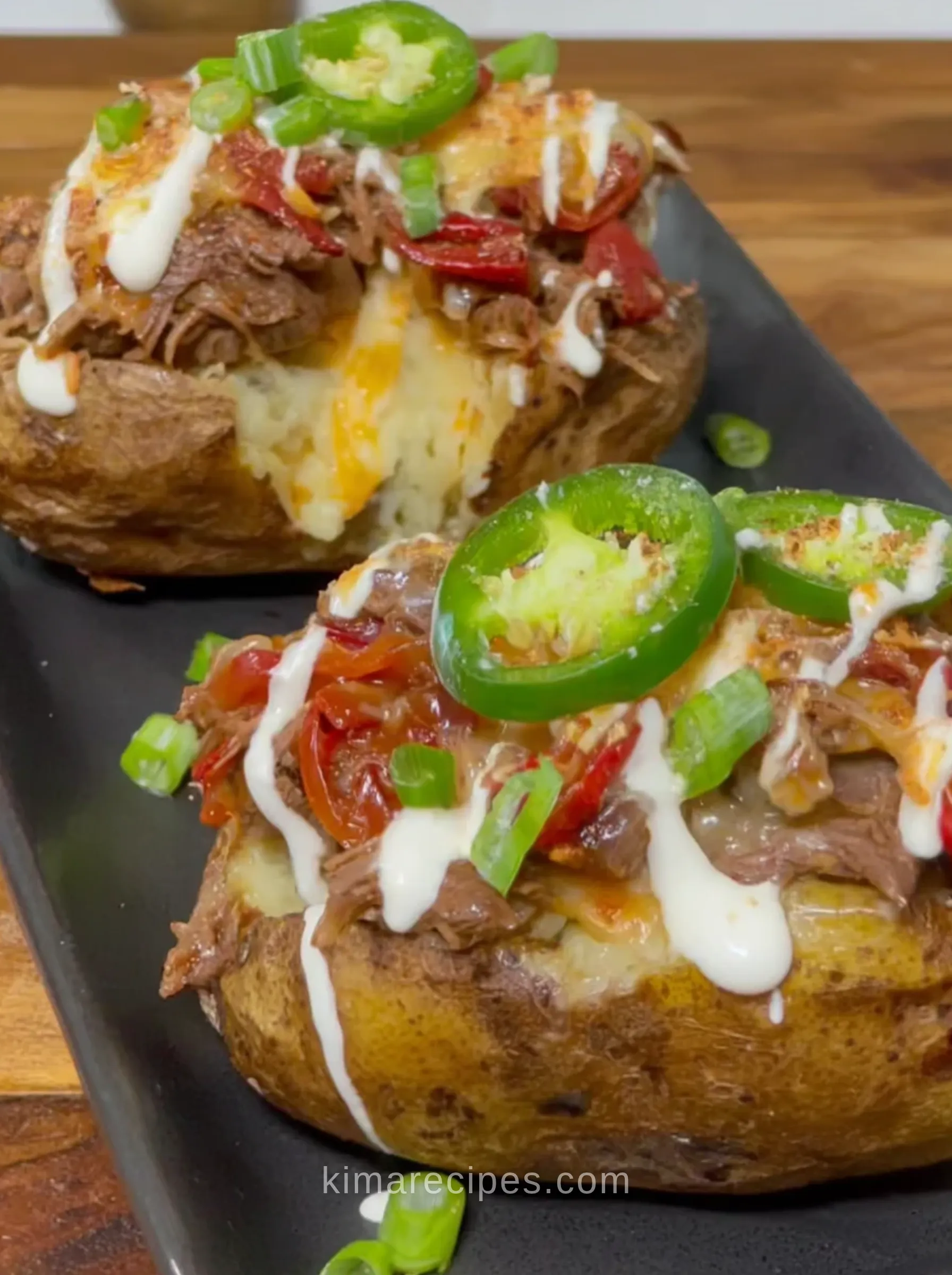 Philly cheesesteak stuffed potatoes topped with shaved ribeye, peppers, melted cheese, sour cream and jalapeño slices