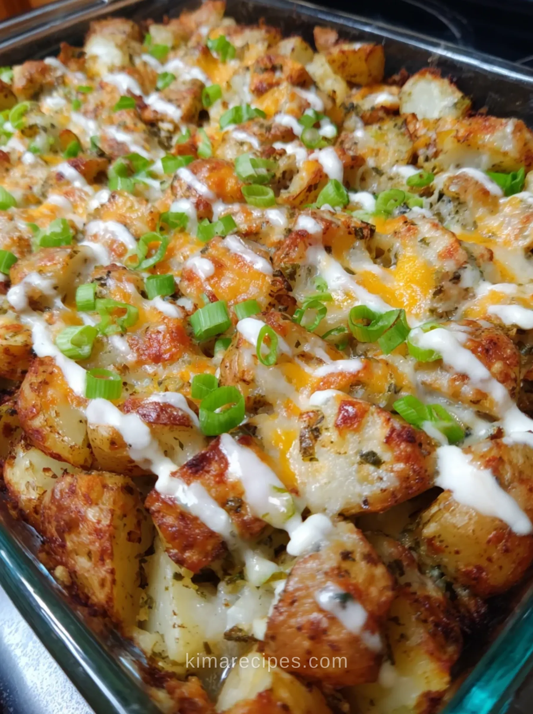 Cheesy ranch potatoes recipe with melted cheddar, ranch drizzle and green onions in a baking dish